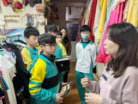 Theater staff guiding students to learn about costume knowledge